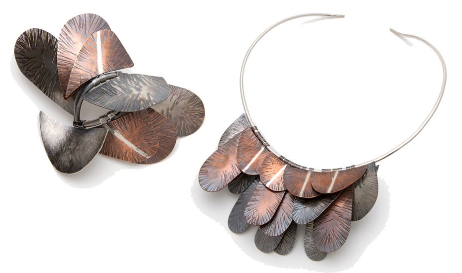 Contemporary necklace and matching brooch featuring layered textured metal shapes in silver and copper tones.